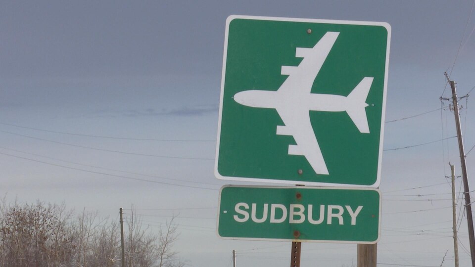 Une pancarte de bord de route indiquant la direction vers l'aéroport de Sudbury.