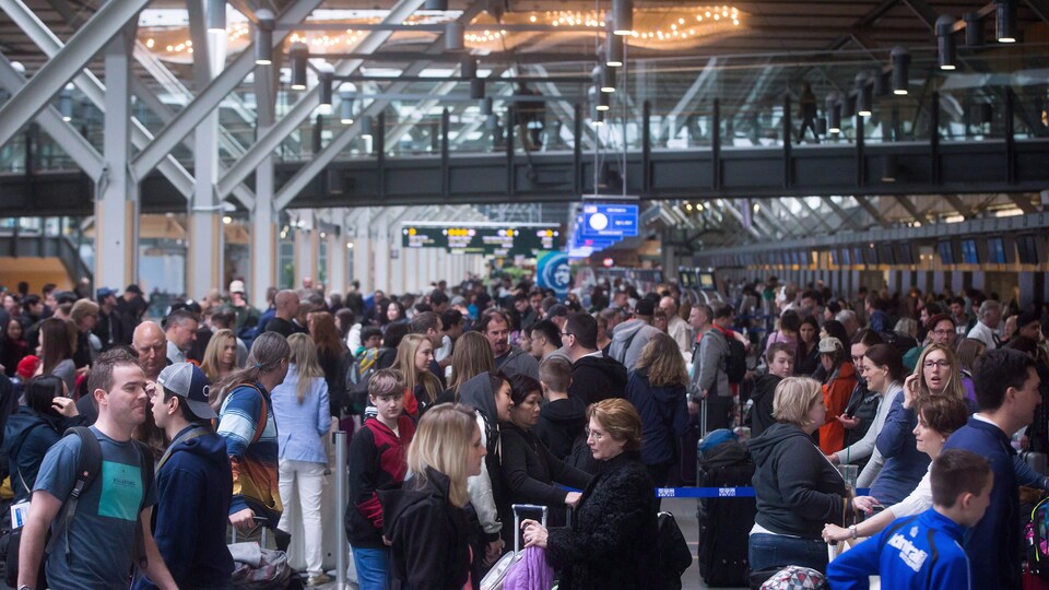 Un nombre important de voyageurs font la queue à l'aéroport international de Vancouver.
