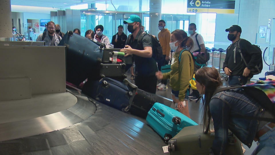 Des passagers récupèrent leurs valises.