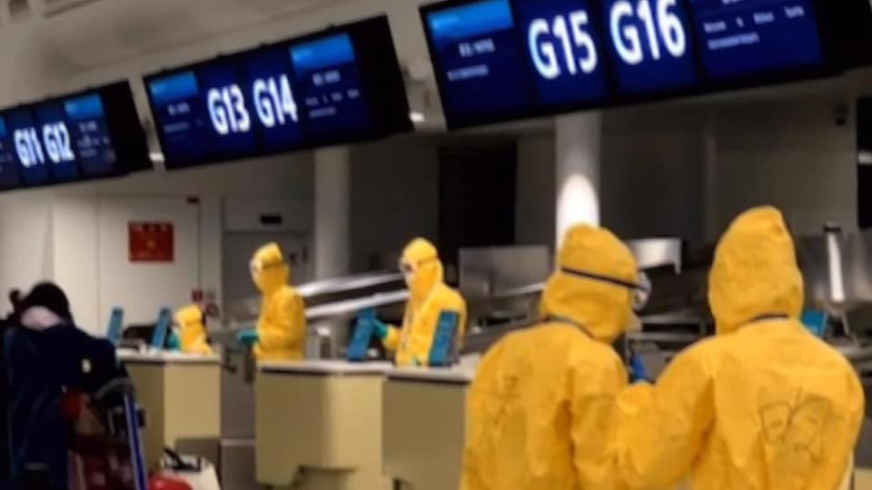 Des travailleurs de l'aéroport portent un habit jaune et des lunettes de protection.