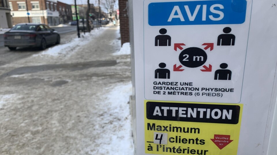Des affiches dans la porte d'un commerce.