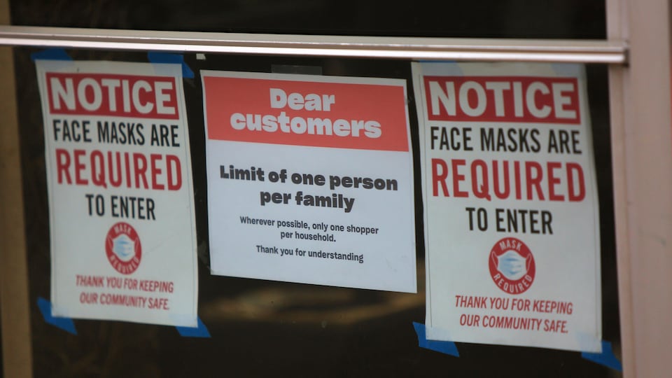 Une affiche dans un commerce annonce que le port du masque est obligatoire