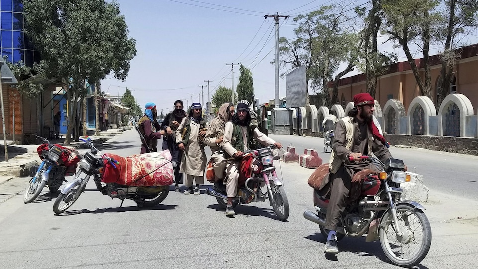 Des talibans sur des motos dans une rue déserte.