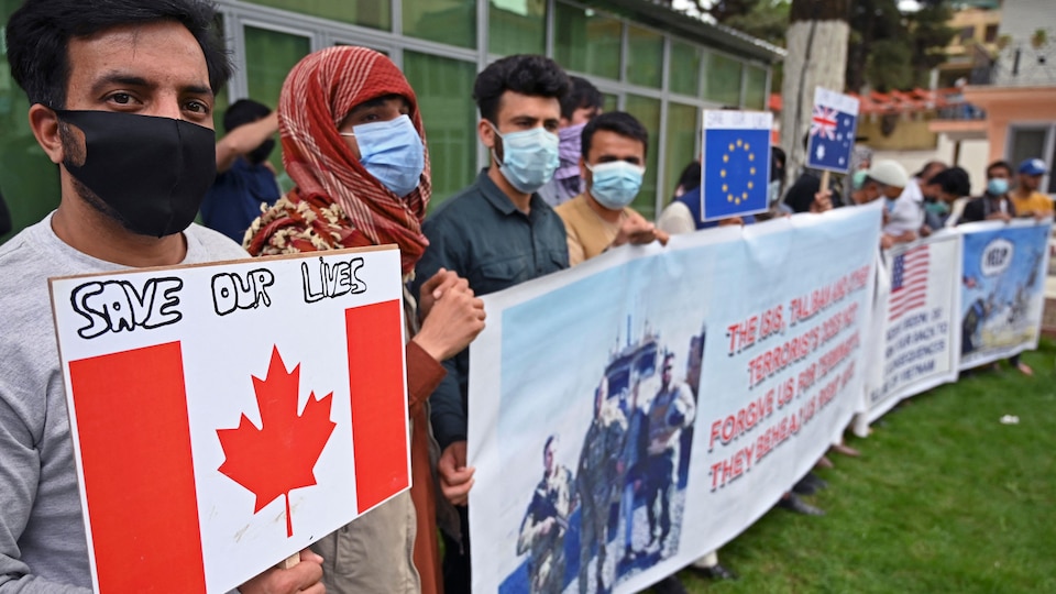 Des manifestants tiennent des banderoles.