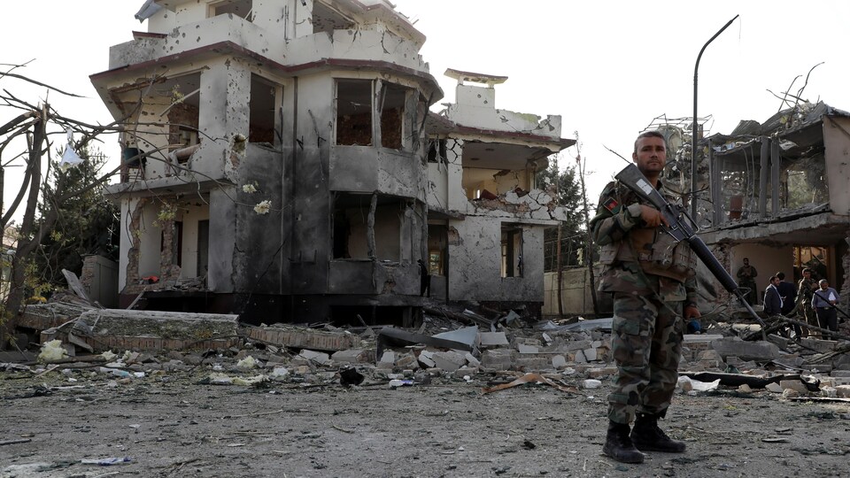 Un soldat devant un édifice en ruines. 