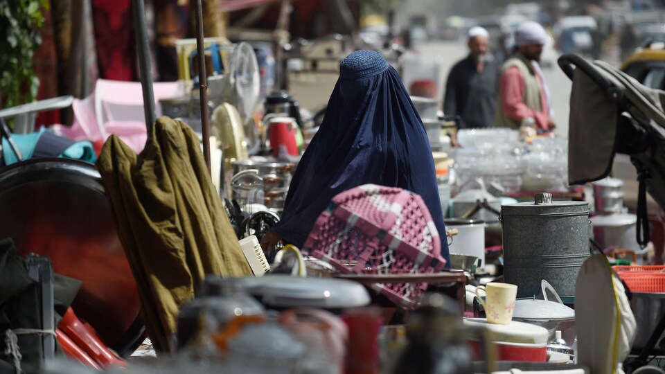Une femme en burqa dans un marché d'occasion du quartier nord-ouest de Khair Khana à Kaboul.