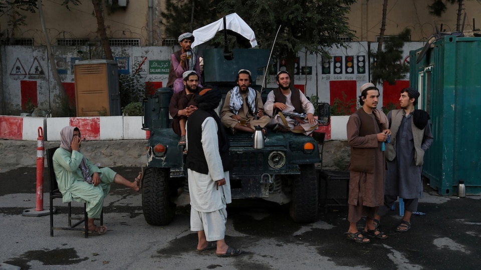 Des hommes armés sont assis sur un véhicule à Kaboul.
