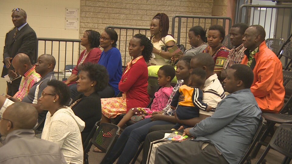 Des membres de la Communauté des Africains francophones de la Saskatchewan sont assis dans une salle lors d'un discours