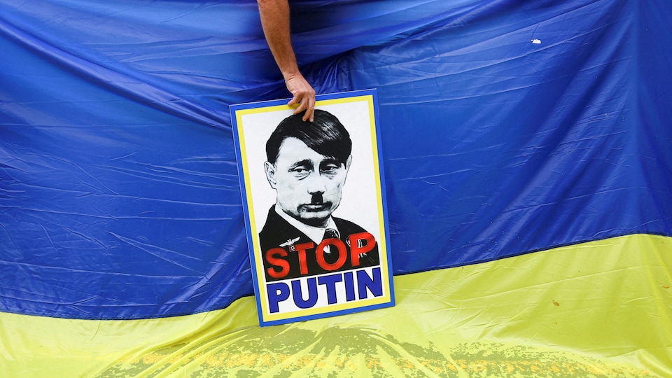 Une affiche représentant Poutine en Hitler sur fond de drapeau ukrainien.