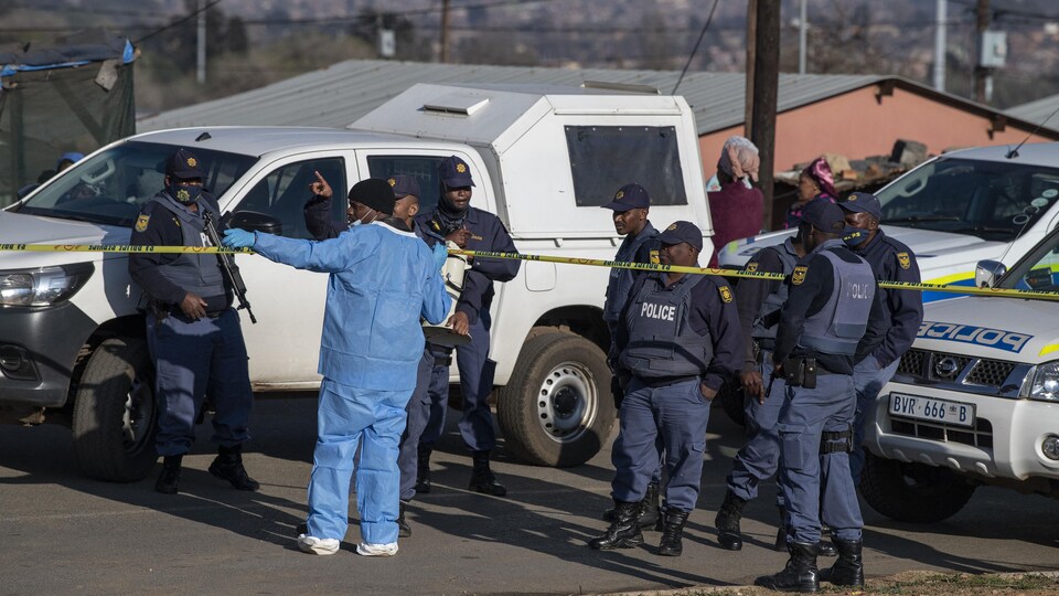 Des policiers sud-africains franchissent un cordon de sécurité.