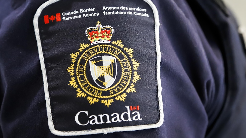 Un écusson de l'Agence des services frontaliers du Canada sur la manche du blouson d'une personne en uniforme.