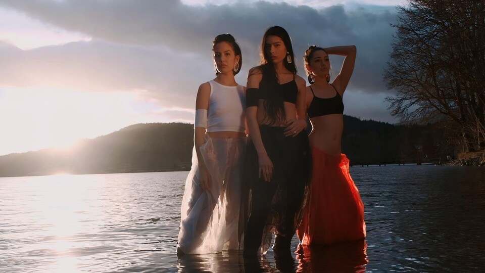 Trois femmes posent les pieds dans l'eau.