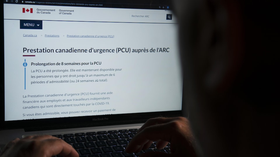 Un homme consulte sur un ordinateur le site de l’Agence du revenu du Canada et de la Prestation canadienne d'urgence.