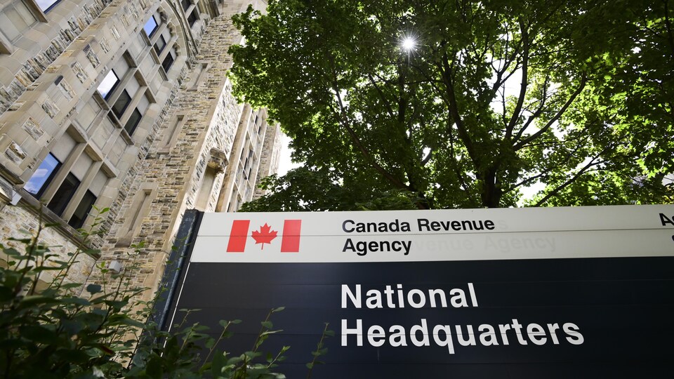 Une pancarte indique l'Agence du revenu du Canada devant un bâtiment de pierre.  