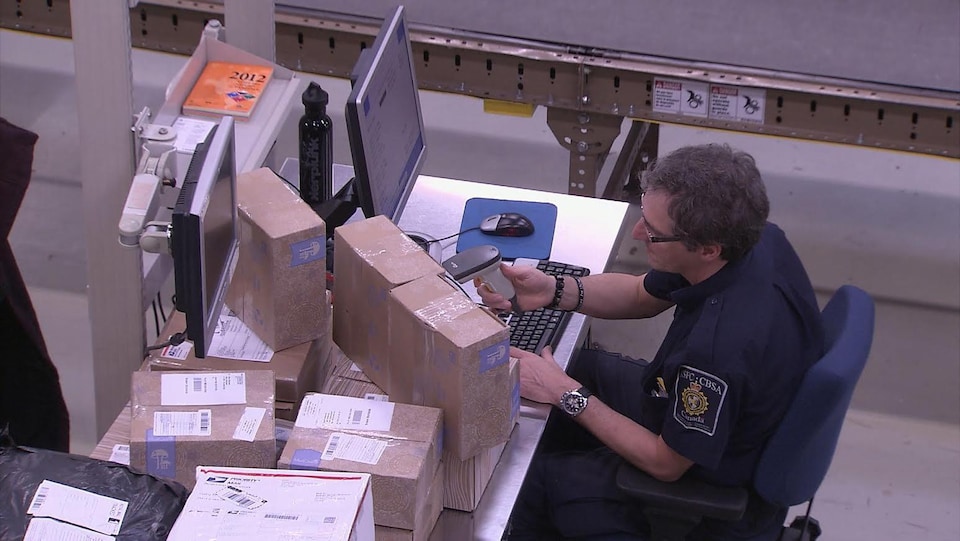 A customs officer scans the packages.