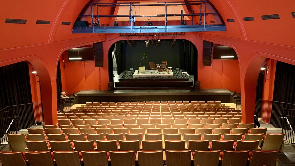 221 bancs devant la scène. Un décor contenant un palmier et deux chaises attend les comédiens.