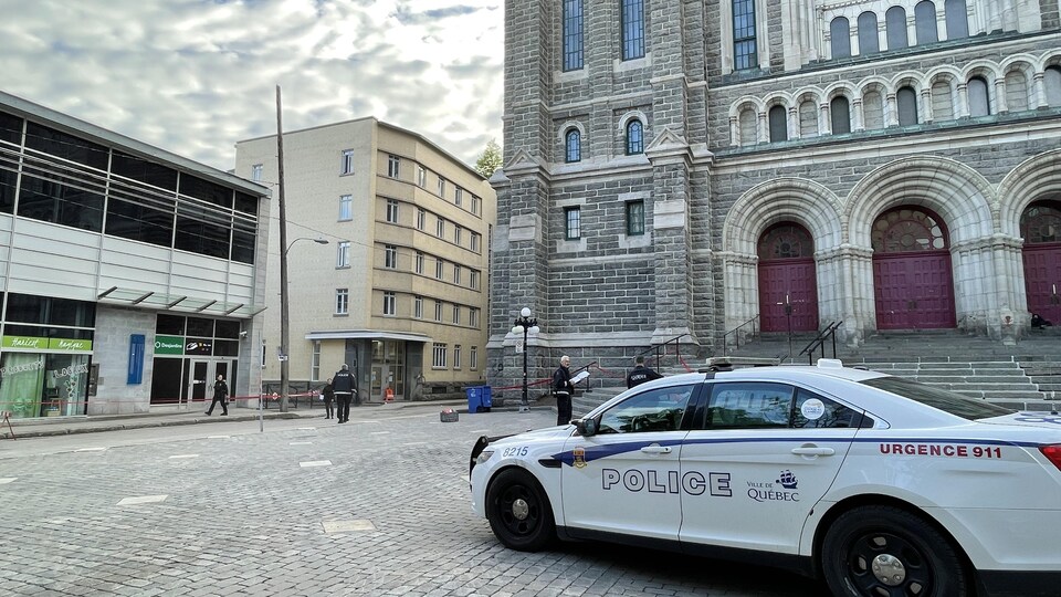 Une voiture de police stationnée sur le parvis de l'église Saint-Roch.