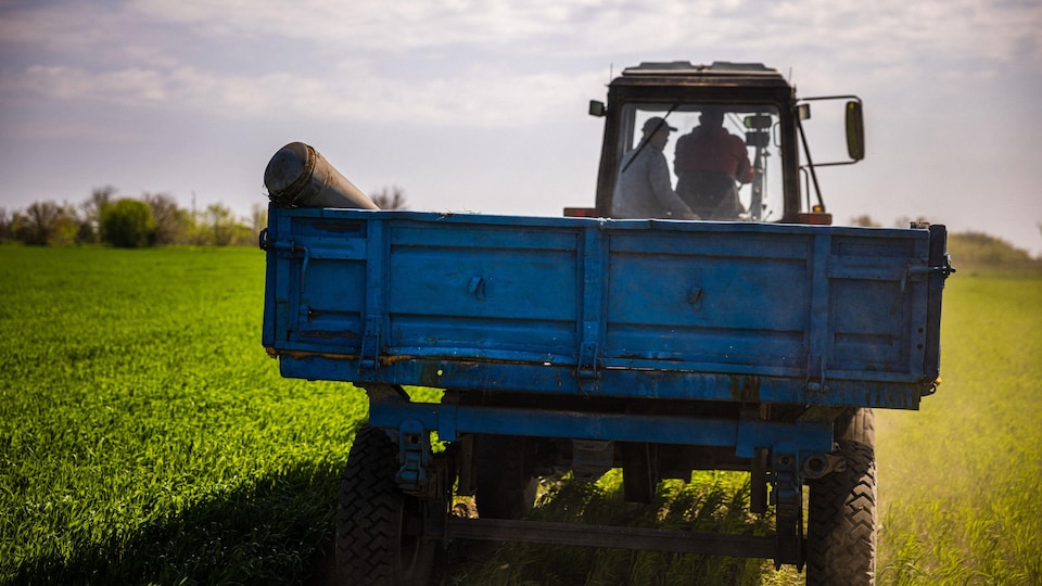 Farmers carry an unexploded missile on a tractor.