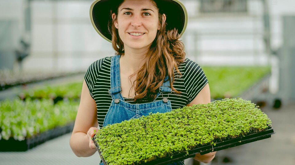 Une jeune agricultrice présente ses étalages.