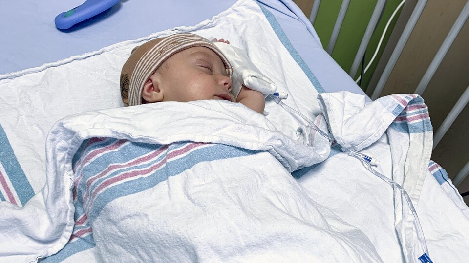 Un nouveau-né endormi dans un lit d'hôpital.