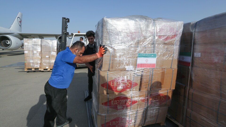 Des travailleurs iraniens remplissant un avion avec des boîtes remplies d'aide humanitaire pour le Liban.