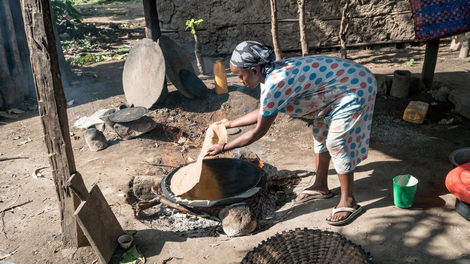 Une femme fait du pain sur un four traditionnel en Éthiopie.