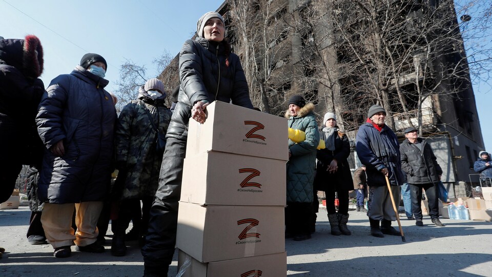 Une foule se rassemble pour recevoir des boîtes de vivres provenant des Russes.
