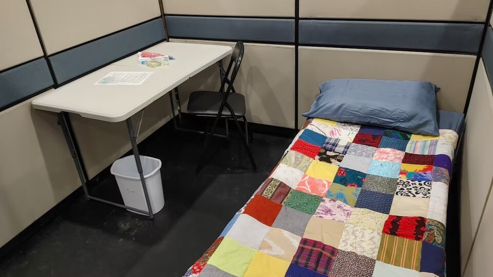La photo d'un espace avec un lit et une table.