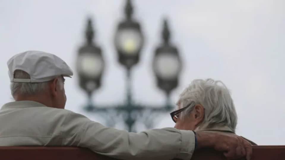 Deux aînés, de dos, assis sur un banc.