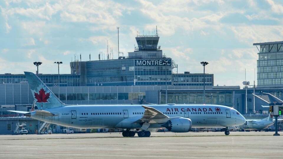 Un avion de la compagnie Air Canada stationné sur le tarmac de l'aéroport de Montréal.
