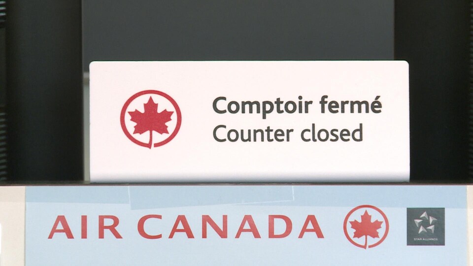 Un comptoir de service fermé d'Air Canada dans un aéroport.