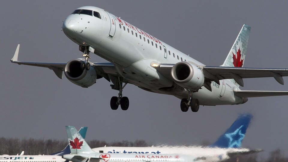 Un avion d'Air Canada décolle près d'autres appareils.