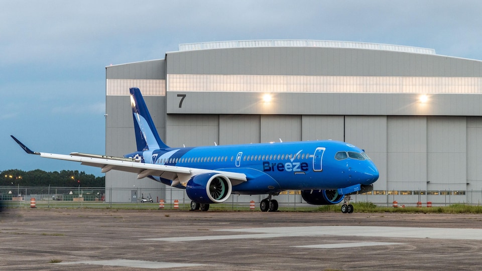 Un A220 d'Airbus peint en bleu et sur lequel on peut lire « Breeze ».