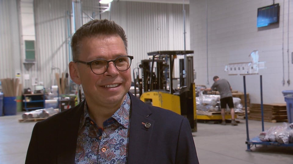Alain Duval accorde une entrevue à Radio-Canada à l'intérieur d'une usine.