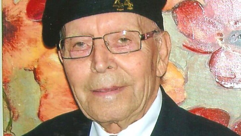 Un homme âgé décoré de médailles.