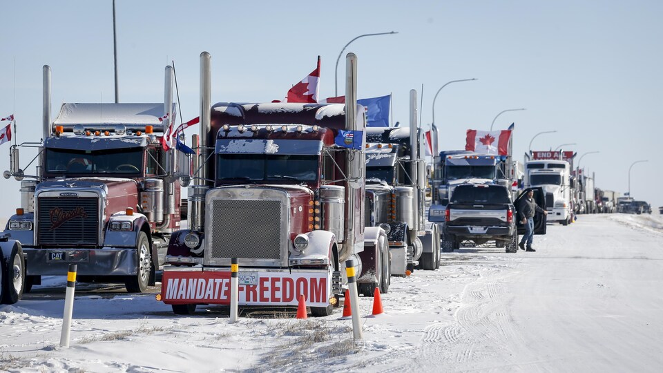 Des camions bloquent l'autoroute au passage frontalier vers les États-Unis de Coutts, en Alberta, le mercredi 2 février 2022. 