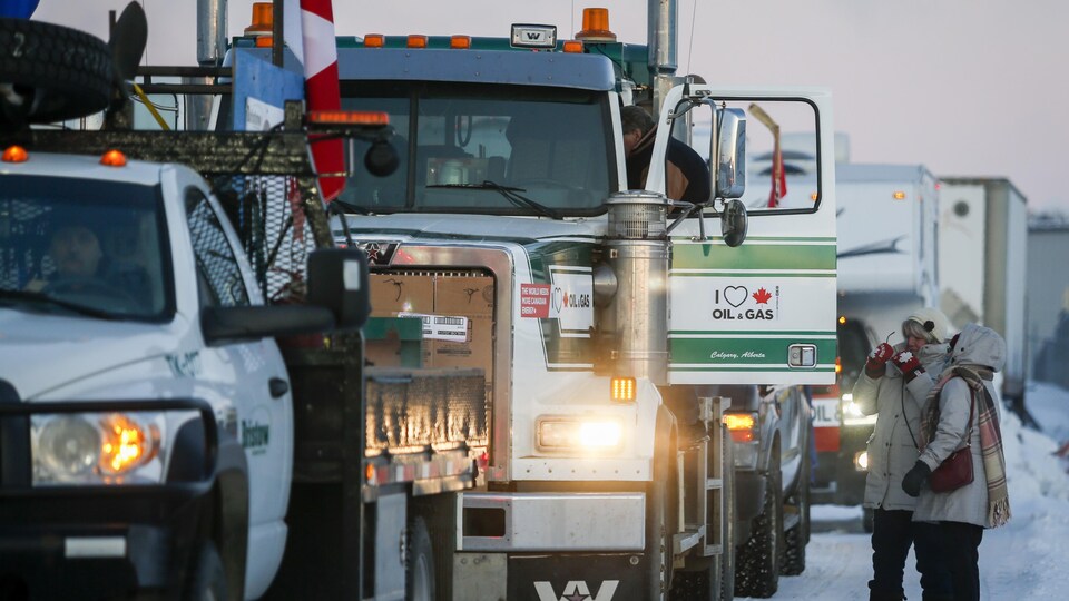 Plusieurs camions d'apprêtent à prendre la route vers Ottawa. Sur l'une des portières, il y a un logo en faveur du pétrole et du gaz canadiens.