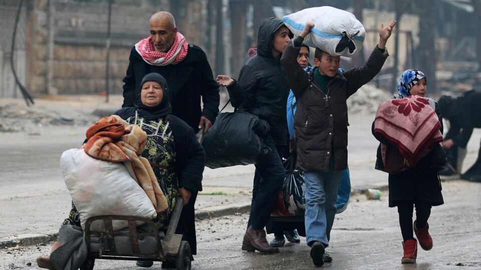 Des habitants d'Alep fuient en emportant le peu de biens qu'ils ont pu sauver.