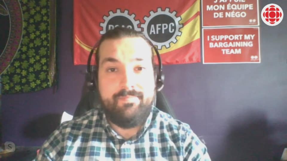 Alex Silas en vidéoconférence, derrière lui un drapeau de l'AFPC 