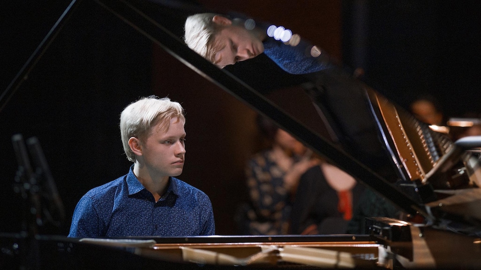 Blond young man playing the piano. 