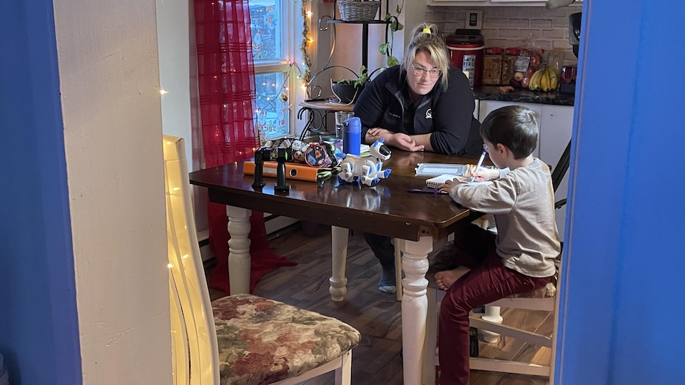 Alexandra Simard aide son fils Antoine à faire ses devoirs. Ils sont installés à la table de la cuisine. 