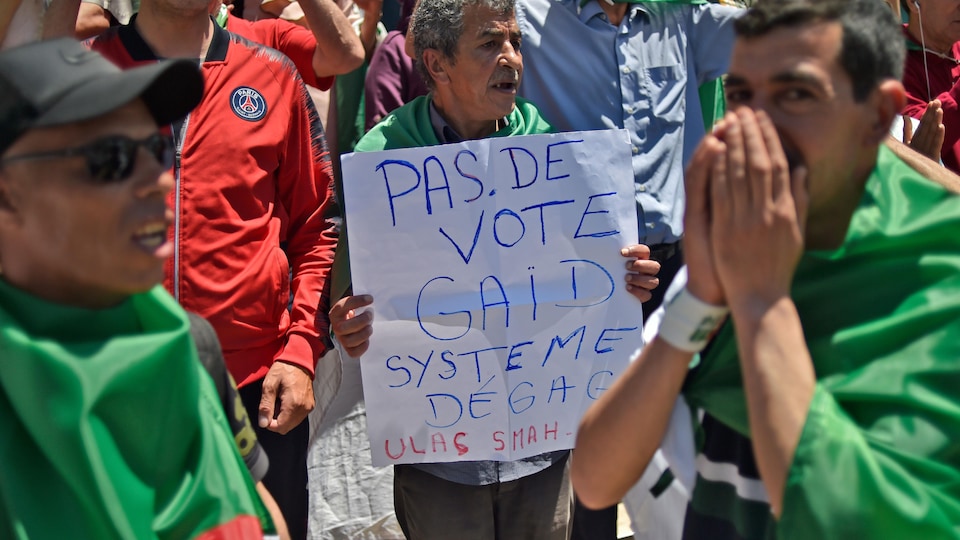 « Pas de vote Gaïd système dégage », peut-on lire sur une pancarte que tient un manifestant. 
