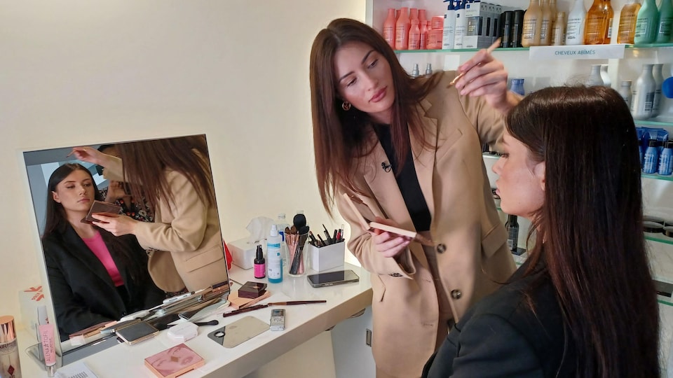 Aliona Antonova maquille une femme devant un miroir.