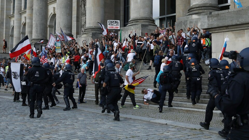 Des policiers interviennent devant le bâtiment du Reichstag pour disperser les manifestants.