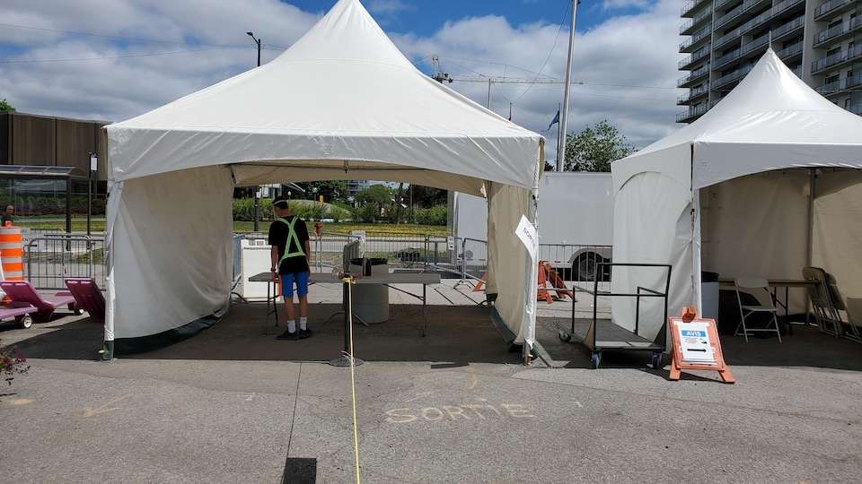 Un jeune préposé sous une tente au Marché public de Sainte-Foy