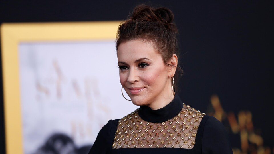 L'actrice Alyssa Milano prend la pose devant les caméras sur le tapis rouge d'une première de film.