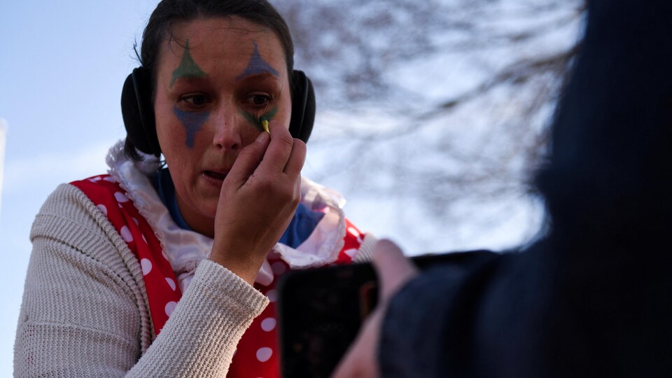 Une femme applique du maquillage sous les yeux.