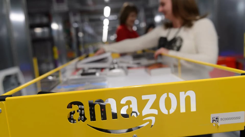 Des femmes travaillent sur une chaîne d'un entrepôt Amazon.