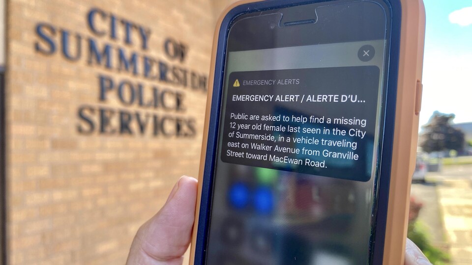 Une alerte d'uurgence sur un iphone placé devant le mur de l'édifice de la police municipale de Sumerville.