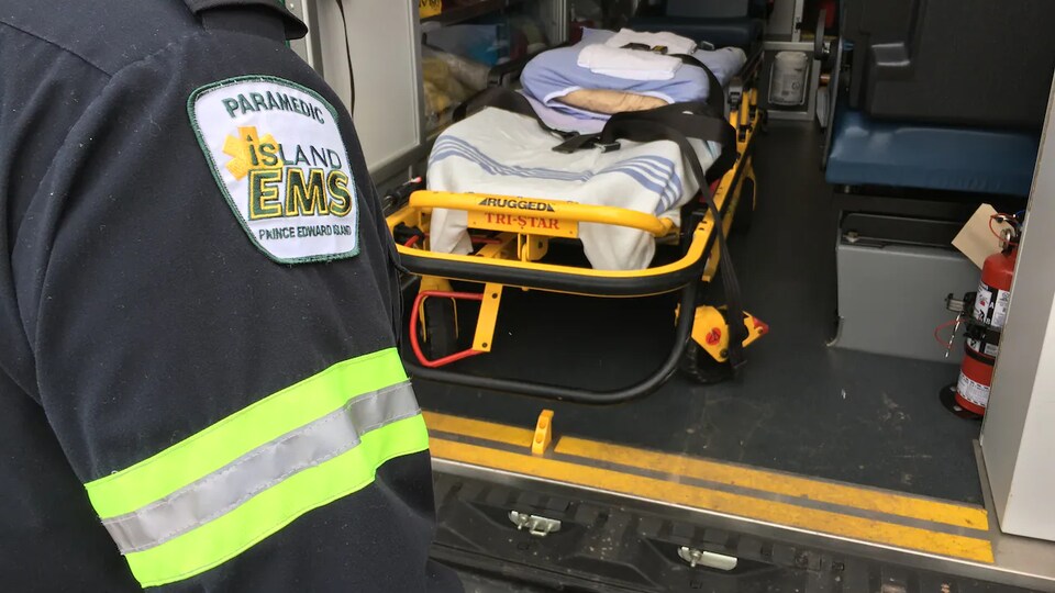 Une civière vide et bras d'ambulancier.